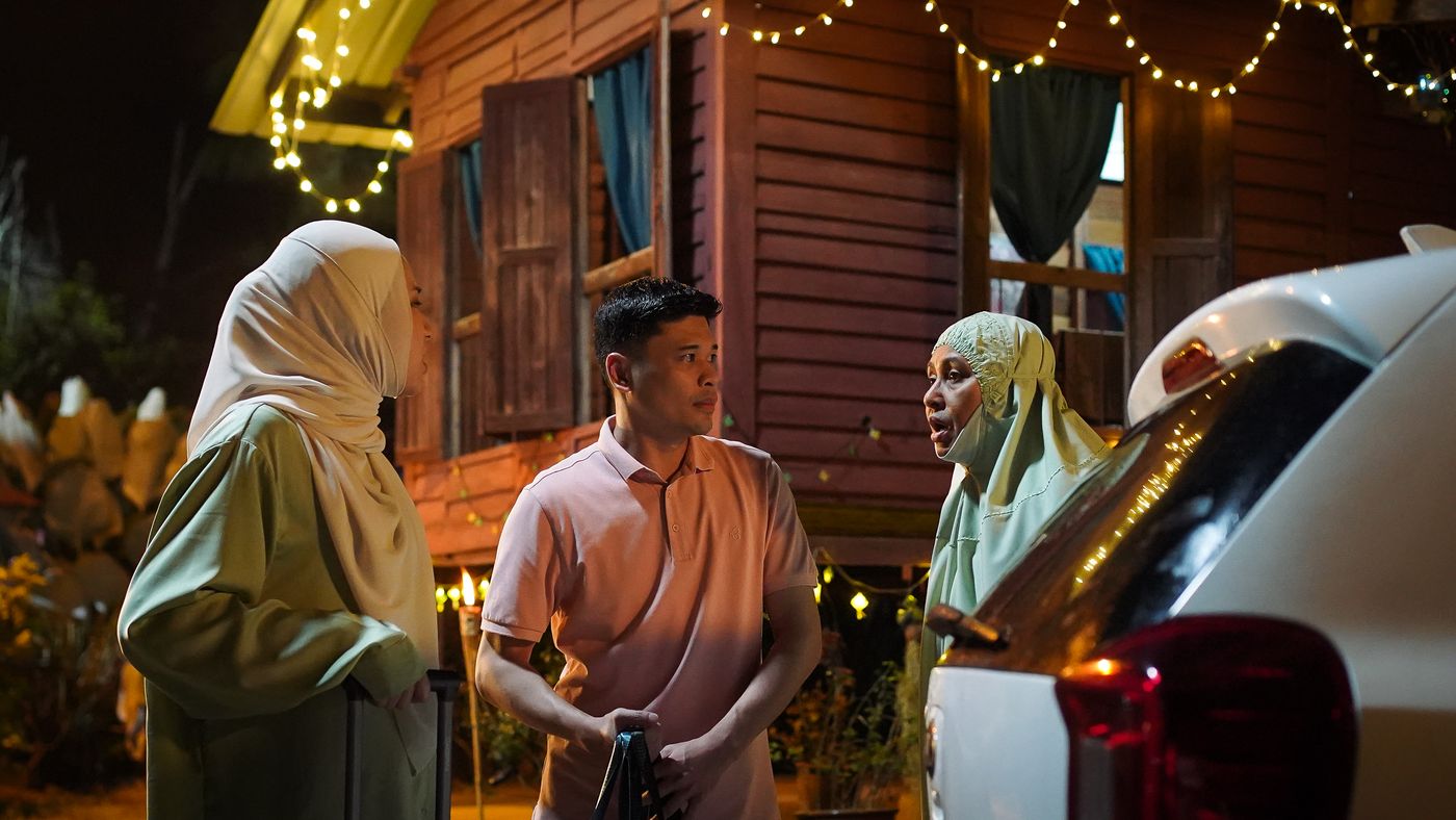 Family scene outside a kampung house